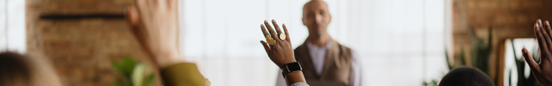Group of people raising hands to ask questions